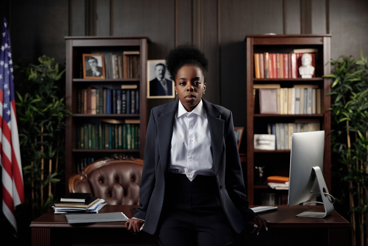 Services African American woman in a suit poses confidently in a law office setting.